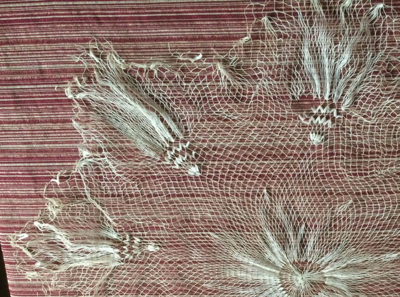 May include: White crocheted lace doily with a delicate floral pattern. The lace is made of fine threads and has a delicate, airy feel.