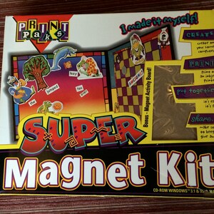 Könnte beinhalten: Eine Schachtel für ein "Print Paks" Super-Magnet-Set. Die Schachtel ist gelb, rot und blau mit einem Bild eines Magnetbretts und einer Vielzahl von bunten Magneten. Der Text auf der Schachtel lautet "Ich habe es selbst gemacht!" und "Super Magnet-Set".