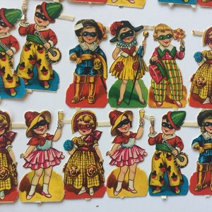 Peut inclure: Un ensemble de 12 poup&eacute;es en papier habill&eacute;es de costumes color&eacute;s, chacune avec un masque et un accessoire unique. Les poup&eacute;es sont pr&ecirc;tes &agrave; &ecirc;tre d&eacute;coup&eacute;es et jou&eacute;es.