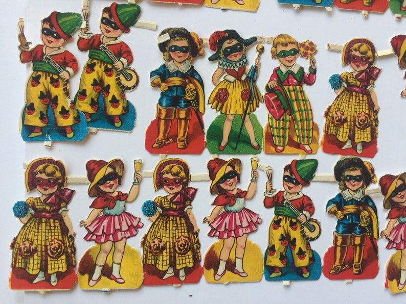 Peut inclure: Un ensemble de 12 poup&eacute;es en papier habill&eacute;es de costumes color&eacute;s, chacune avec un masque et un accessoire unique. Les poup&eacute;es sont pr&ecirc;tes &agrave; &ecirc;tre d&eacute;coup&eacute;es et jou&eacute;es.