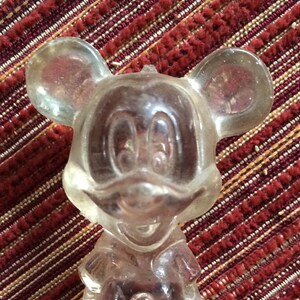 Puede incluir: Una figurita de cristal transparente de Mickey Mouse. La figurita est&aacute; detallada con las orejas, los ojos y la nariz caracter&iacute;sticas de Mickey.