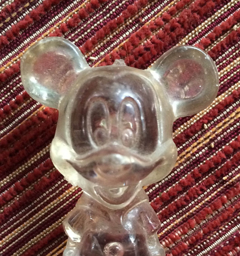 Puede incluir: Una figurita de cristal transparente de Mickey Mouse. La figurita est&aacute; detallada con las orejas, los ojos y la nariz caracter&iacute;sticas de Mickey.