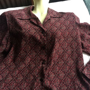 Könnte beinhalten: Ein langärmliges Hemd mit Knöpfen und einem rot-schwarz-weißen Muster.