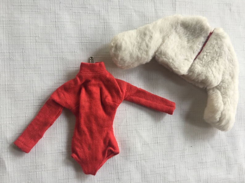 May include: A red long-sleeved leotard with a turtleneck and a white faux fur jacket.