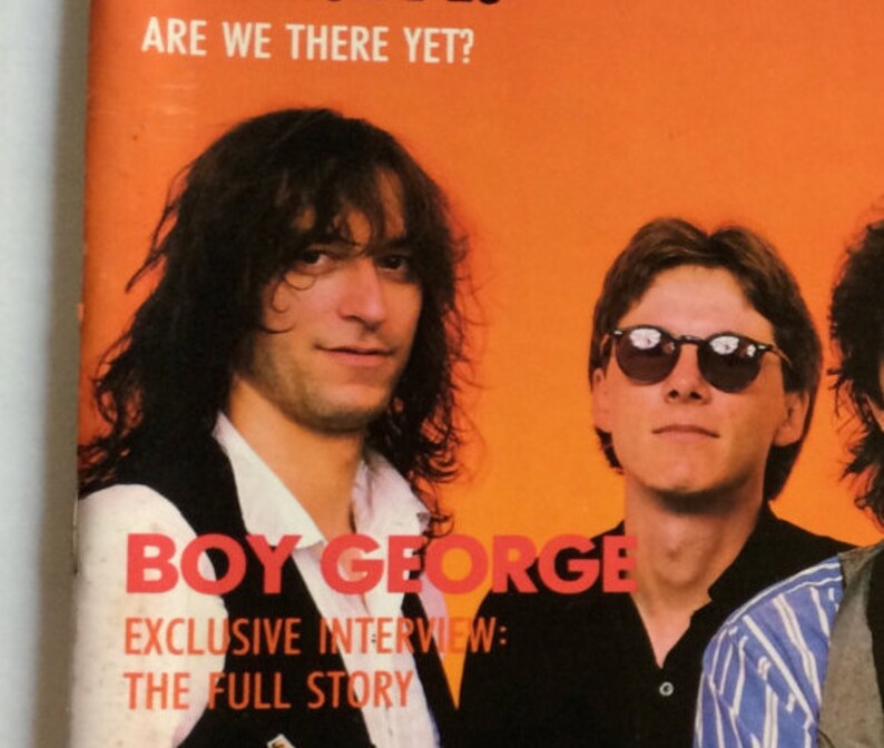 May include: A magazine cover featuring a photo of Boy George, a British singer-songwriter, with the text "Boy George" and "Exclusive Interview: The Full Story" in red letters. The cover also features the text "Are We There Yet?" in white letters.