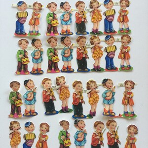 Peut inclure: Un ensemble de 24 poup&eacute;es en papier vintage repr&eacute;sentant des enfants jouant d'instruments de musique. Les poup&eacute;es sont habill&eacute;es de v&ecirc;tements color&eacute;s et tiennent des instruments tels qu'un violon, un accord&eacute;on, une trompette et un tambour. Les poup&eacute;es sont imprim&eacute;es sur du papier &eacute;pais et sont en excellent &eacute;tat.