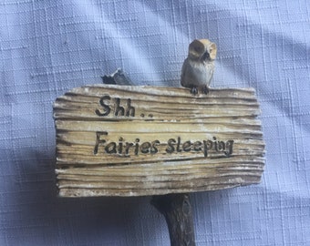 May include: A wooden sign with the text "Shh... Fairies Sleeping" and a small owl figurine perched on top.