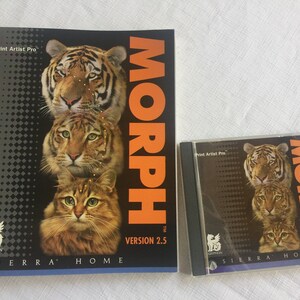 May include: A computer software package for the Print Artist Pro program. The box features a black background with a stack of three animals, a tiger, a cat, and a tabby cat. The title of the software is "MORPH" in orange letters. The text "VERSION 2.5" is in white letters. The software is from Sierra Home.