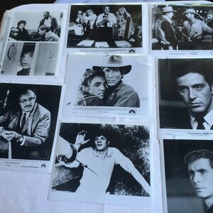 May include: A collection of black and white photographs featuring various scenes and people. The photographs are displayed on a white surface.