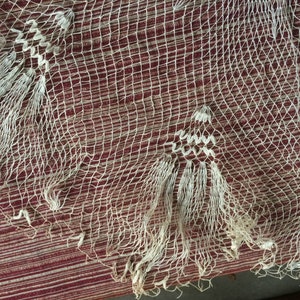 May include: White crocheted lace fabric with a delicate pattern. The lace has a fringe border and is made of fine, lightweight yarn.