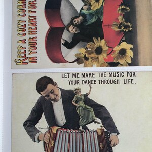 K&ouml;nnte beinhalten: Zwei Vintage-Postkarten mit romantischen Motiven. Eine Karte tr&auml;gt den Text "KEEP A COZY CORNER IN YOUR HEART FOR ME" mit einem Paar und Sonnenblumen. Die andere zeigt einen Mann, der Akkordeon spielt, mit einer tanzenden Frau und dem Text "LET ME MAKE THE MUSIC FOR YOUR DANCE THROUGH LIFE."