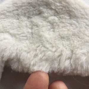 May include: A white fluffy faux fur hat with a wide brim.