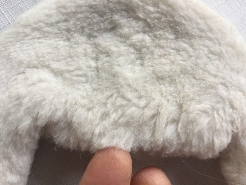 May include: A white fluffy faux fur hat with a wide brim.