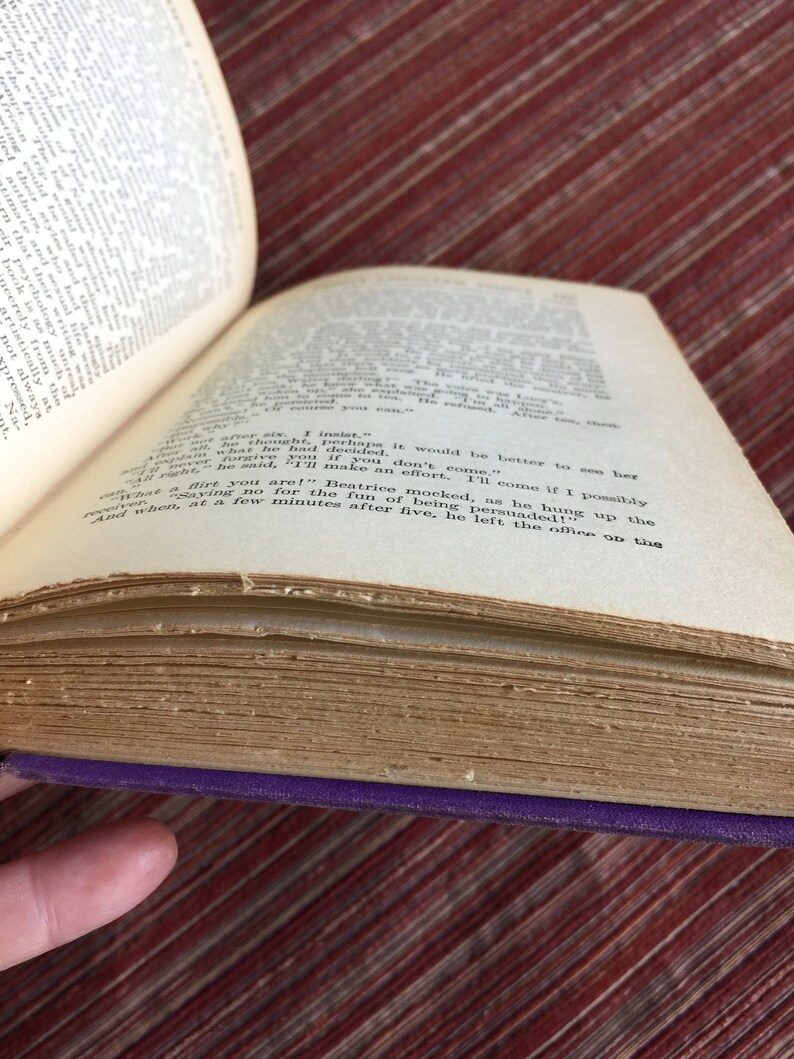 May include: A close-up of an open book with yellowed pages. The text on the page reads "And when, at a few minutes after five, he left the office to go up the...