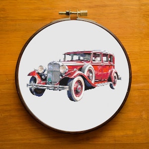 Puede incluir: Un coche rojo vintage con detalles cromados y neumáticos de banda blanca. El coche está sobre un fondo blanco.