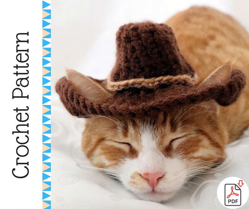 K&ouml;nnte beinhalten: Ein brauner geh&auml;kelter Cowboyhut mit einem braunen Band sitzt auf dem Kopf einer schlafenden orange-wei&szlig;en Katze. Die Katze liegt auf einer wei&szlig;en Oberfl&auml;che. Das Bild enth&auml;lt den Text "Crochet Pattern" und ein Download-Symbol.