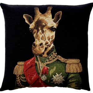May include: A black and gold tapestry cushion featuring a giraffe wearing a military uniform with a red sash and gold trim. The giraffe has a serious expression and is looking directly at the viewer.