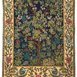 May include: A rectangular woven tapestry featuring a central dark blue field with a large flowering tree, green foliage, and small birds. The design is framed by a wide cream-colored border decorated with intricate floral vines, leaves, and blossoms.