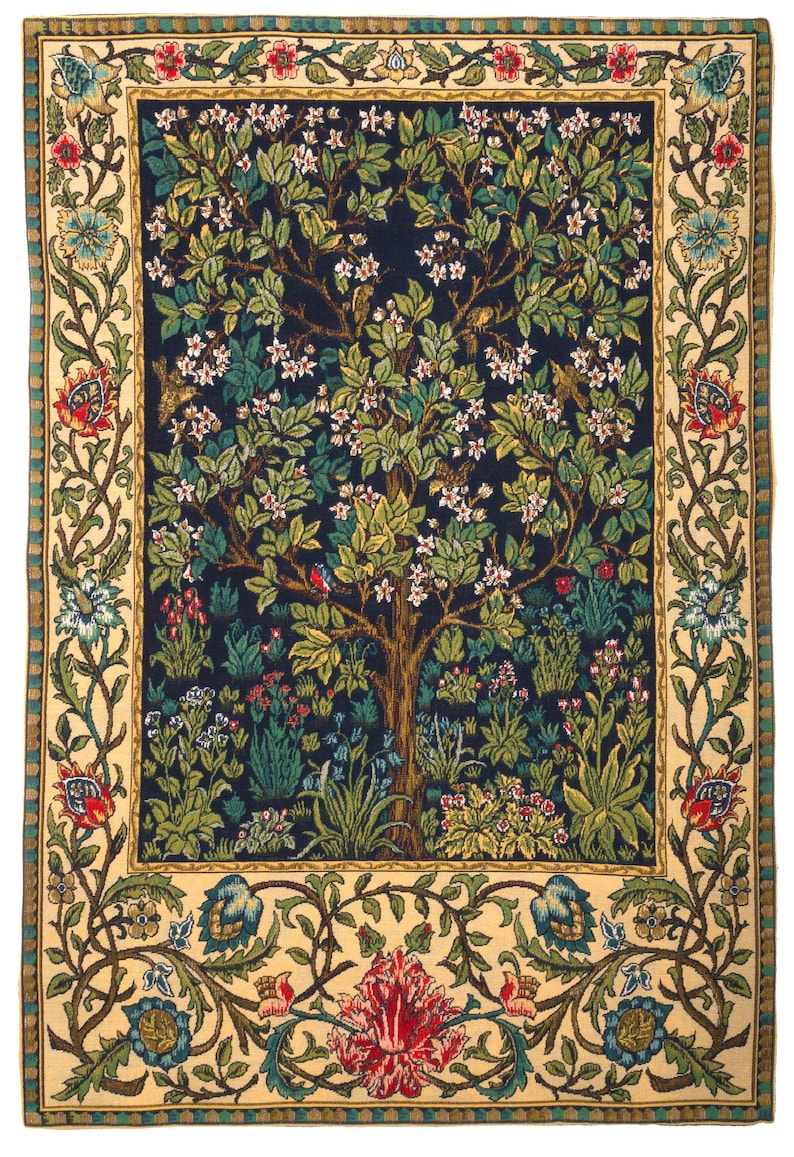 May include: A rectangular woven tapestry featuring a central dark blue field with a large flowering tree, green foliage, and small birds. The design is framed by a wide cream-colored border decorated with intricate floral vines, leaves, and blossoms.