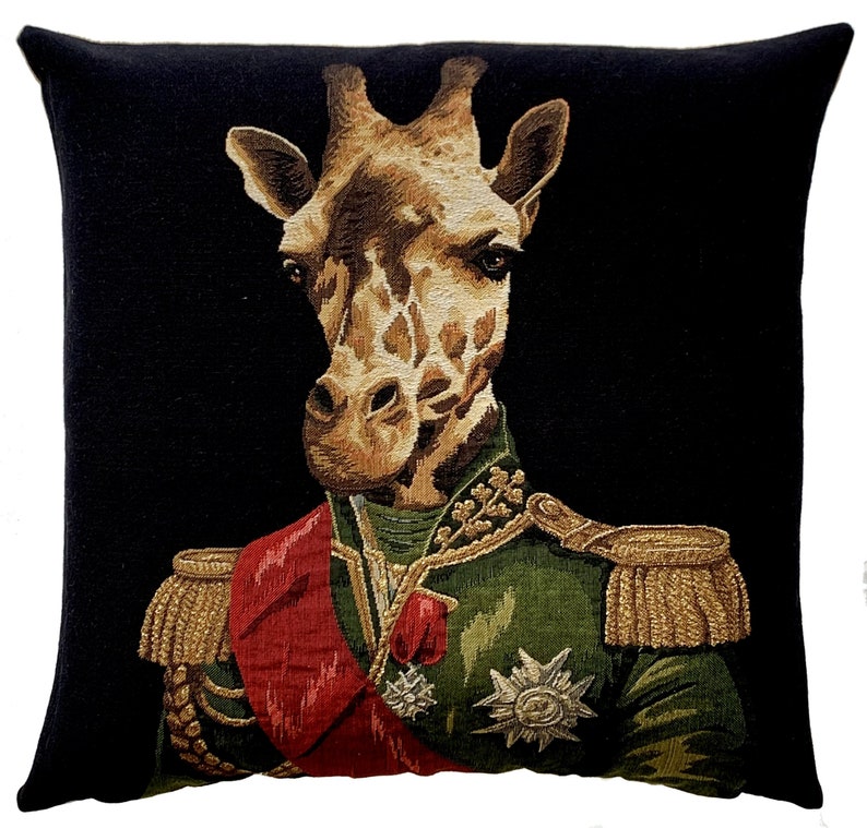 May include: A black and gold tapestry cushion featuring a giraffe wearing a military uniform with a red sash and gold trim. The giraffe has a serious expression and is looking directly at the viewer.