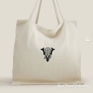 May include: A white canvas tote bag with a black embroidered monogram of the letters "BV" in a decorative font. The bag has two long handles and the text "Royal Present Embroidery" is printed on the bottom of the bag.
