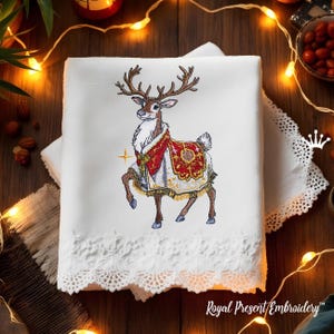 May include: Embroidered design of a reindeer wearing a red and gold robe with intricate details. The reindeer is standing on a white background.