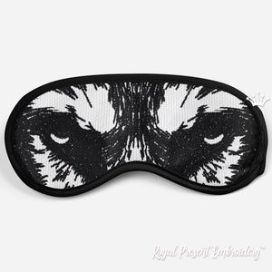 May include: Black and white sleep mask with an embroidered wolf face design.