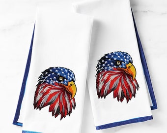 Puede incluir: Dos toallas de cocina blancas con ribete azul, cada una con una imagen bordada de un águila calva americana con el diseño de la bandera estadounidense. El texto "Royal Present Embroidery" es visible en la esquina inferior derecha.