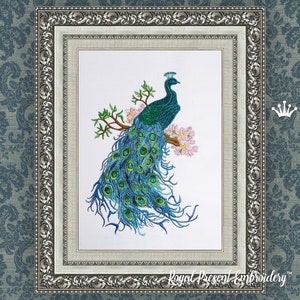 May include: Embroidered artwork of a peacock with a long, flowing tail, perched on a branch with pink blossoms. The peacock is in shades of blue and green, set in a silver ornate frame. The background is a patterned blue.