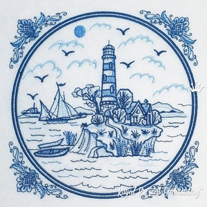 Puede incluir: Un diseño de bordado azul y blanco de un faro en una pequeña isla con un velero en el agua. El diseño está en un círculo con un borde floral.