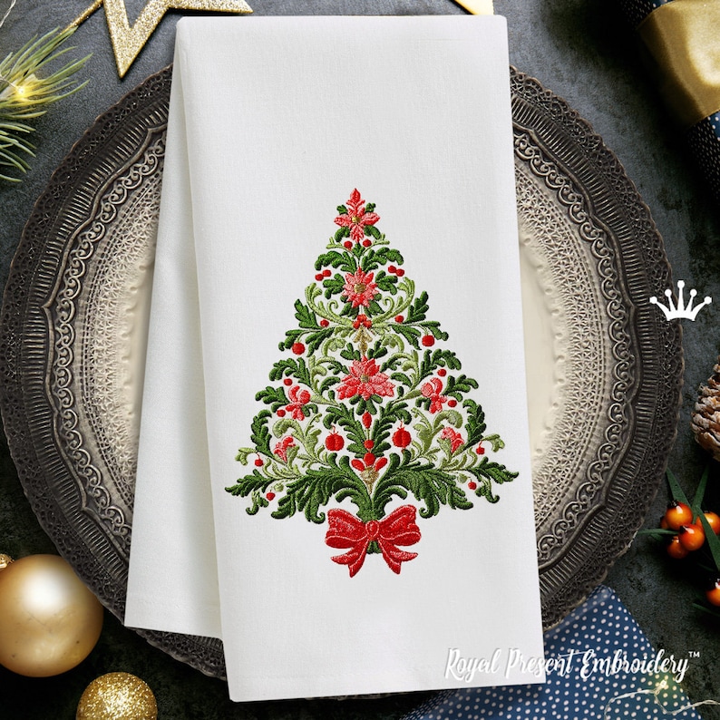 K&ouml;nnte beinhalten: Stickmuster eines Weihnachtsbaums auf einer wei&szlig;en Leinen-Serviette. Der Baum ist mit roten Weihnachtssternen, gr&uuml;nen Bl&auml;ttern und roten Beeren verziert. Eine rote Schleife ist an der Basis des Baumes gebunden.