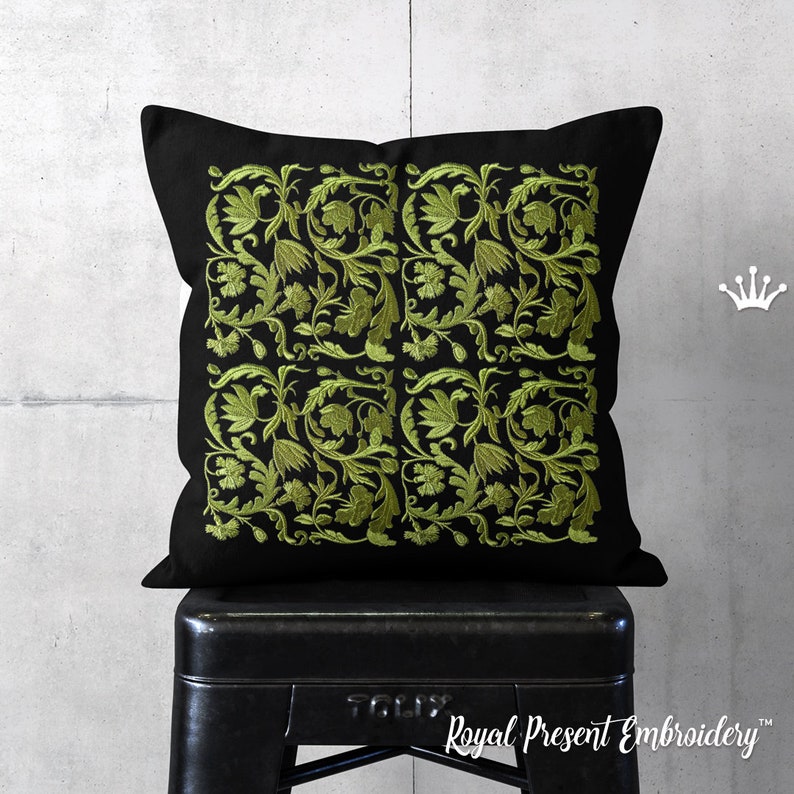 May include: A black pillow with a green embroidered floral pattern. The pillow is sitting on a black stool.