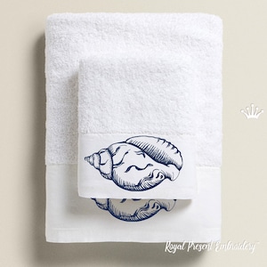Puede incluir: Dos toallas de baño blancas con un diseño de concha marina bordada en azul. Las toallas están dobladas y apiladas una encima de la otra. La toalla de abajo tiene el texto "Royal Present Embroidery" impreso en el borde inferior.