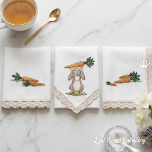May include: Three white linen napkins with embroidered carrot and bunny designs. One napkin features a bunny holding a carrot, while the others have carrot clusters. Each napkin has a beige lace trim, perfect for Easter.