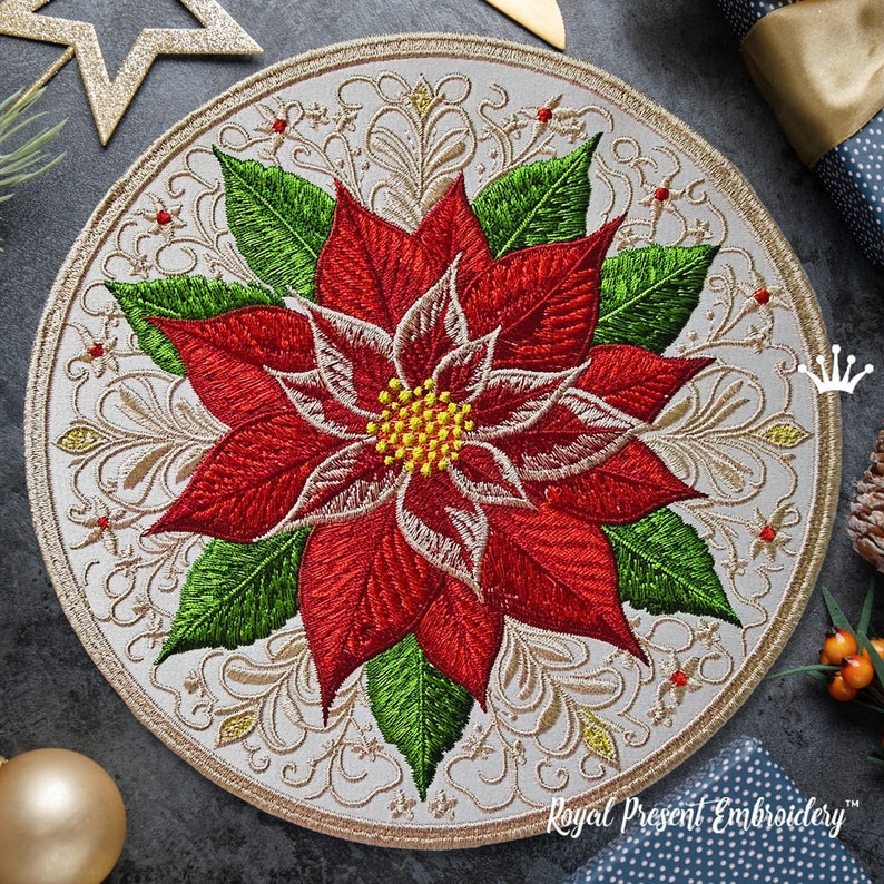 Peut inclure: Un &eacute;cusson brod&eacute; circulaire repr&eacute;sentant une fleur de poinsettia rouge vif avec des feuilles vertes et un centre jaune, sur un fond clair avec des volutes dor&eacute;es complexes et de petits accents rouges, bord&eacute; d'une couture dor&eacute;e.