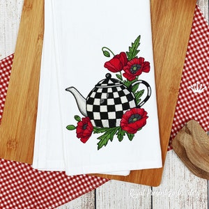 Könnte beinhalten: Bestickte Geschirrhandtuch mit einer schwarz-weiß karierten Teekanne und roten Mohnblumen. Das Design ist auf einem weißen Stoff gestickt.