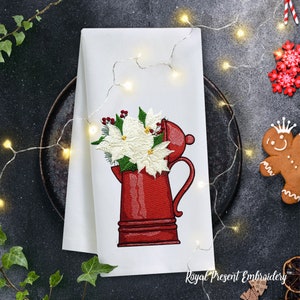 Op de afbeelding: Geborduurde keukendoek met een rode theepot met een boeket witte kerststerren.