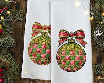 Peut inclure: Deux torchons de cuisine blancs avec des ornements de Noël brodés. Chaque ornement est vert, rouge et or avec un nœud rouge et vert.