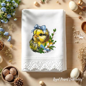 May include: Embroidered design of a yellow chick with a blue bow on a white towel with a lace trim. The chick is surrounded by green leaves and white flowers.