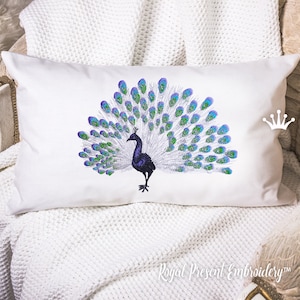 May include: White rectangular pillow featuring an embroidered peacock with a fanned tail. The peacock has a dark purple body and a crown. The tail feathers are blue and green. The pillow is on a white blanket.