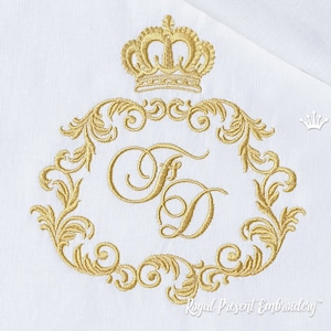 Könnte beinhalten: Gold gesticktes Monogramm mit einer Krone und verzierten Ranken. Das Monogramm zeigt die Buchstaben "FD".