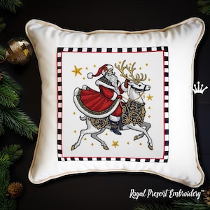 Puede incluir: Almohada blanca con un borde a cuadros blanco y negro. El centro de la almohada presenta una imagen bordada de Santa Claus montando un reno. El reno es blanco con detalles dorados y el fondo es blanco con estrellas doradas.