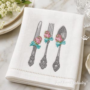 May include: White embroidered kitchen towel with a knife, fork, and spoon design. Each utensil is decorated with pink flowers and a turquoise ribbon. The towel has a decorative stitched border and the text "Royal Present Embroidery".
