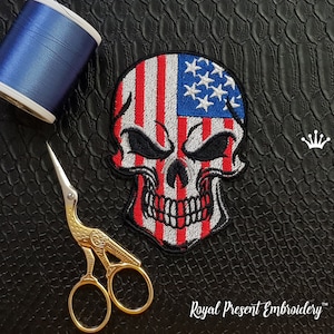 May include: Embroidered patch of a skull with an American flag design. The skull is white with black eyes and a red mouth. The flag is red, white, and blue. The patch is on a black background.