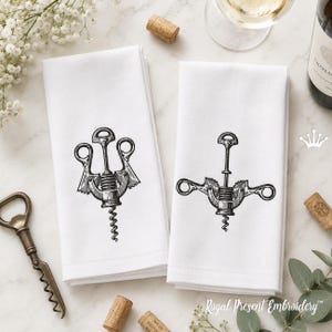 May include: Two white napkins with black embroidered corkscrew designs. The napkins are folded on a marble surface, with corks, a bottle opener, and a wine bottle. The napkins are part of the Royal Present Embroidery collection.