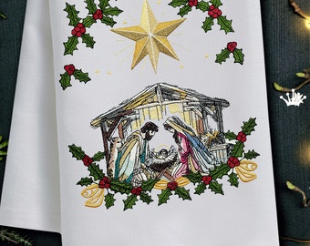 May include: Embroidered Christmas design featuring a nativity scene with Mary, Joseph, and baby Jesus in a manger. The scene is surrounded by a wreath of holly with red berries and a gold star above.