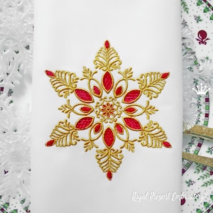 Peut inclure: Broderie de flocon de neige dorée et rouge. Le flocon de neige est détaillé avec des volutes et des feuilles complexes.