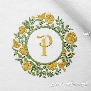 Puede incluir: Diseño de monograma bordado con la letra "P" en una fuente de escritura dorada rodeada de una corona de hojas verdes y flores amarillas.