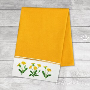 Pode incluir: Uma toalha de cozinha amarela com uma borda branca e dentes-de-le&atilde;o amarelos bordados. A toalha est&aacute; dobrada ao meio e tem um fundo branco com o texto "Royal Present Embroidery" em preto.