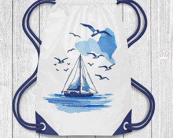 Puede incluir: Bolsa de cordón blanco con un diseño bordado azul de un velero en el agua con gaviotas volando por encima. La bolsa tiene cordones de color azul.